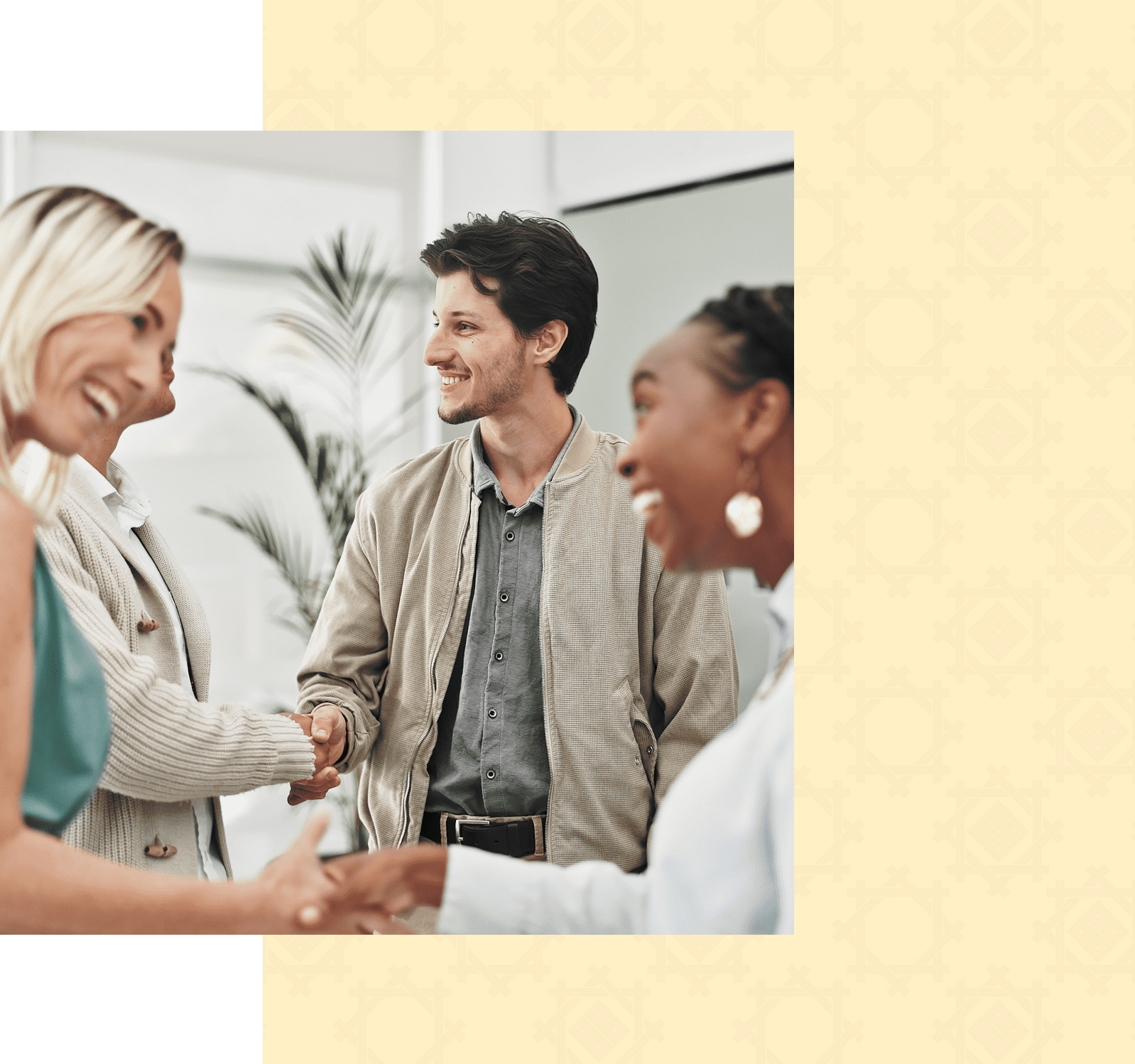 Three people stand indoors, smiling and shaking hands, suggesting a friendly or professional meeting. A green and beige patterned border frames the image.